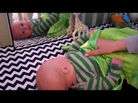 Baby Fascinated With Mirror Reflection in Crib