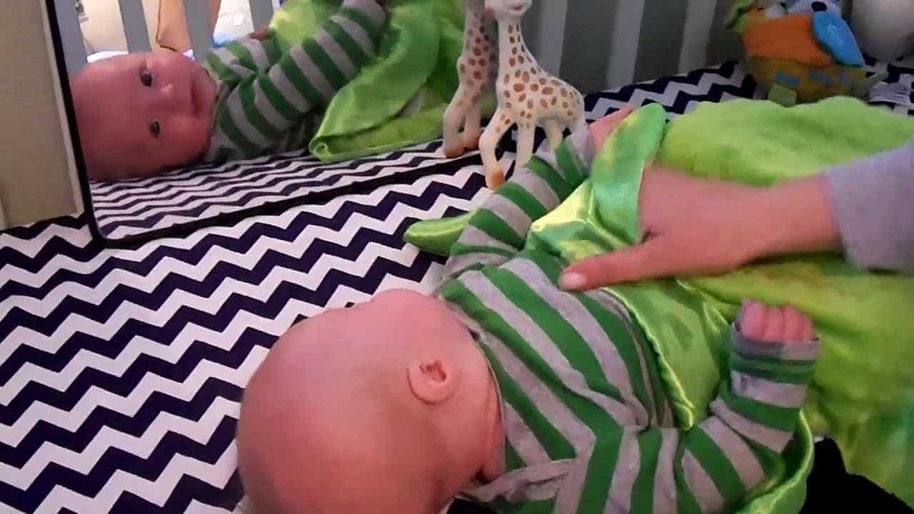 Baby Fascinated With Mirror Reflection in Crib